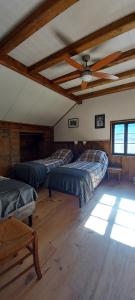 a room with three beds and a ceiling fan at Chambre d'hotes le cycliste in La Chapelle