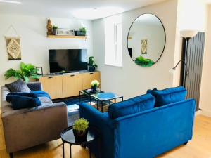 a living room with two blue couches and a tv at Modern luxurious house with Parking and Garden in Bath