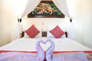 a bed with two towels in the shape of a heart at Raka House Accommodation in Ubud