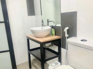 La salle de bains est pourvue d'un lavabo blanc sur un support en bois. dans l'établissement Minimalist Boho Loft,2-6pax, The Curve, IKEA, Bandar Utama, Damansara, à Petaling Jaya