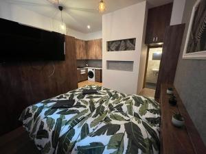 Un dormitorio con una cama con una manta estampada de hojas en Ubytování Tajemství Lucy, en Skvrňany