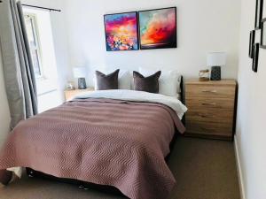 a bedroom with a large bed and a dresser at Modern luxurious house with Parking and Garden in Bath
