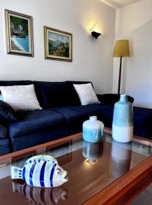 a living room with a blue couch and a glass table at La Ca Dei Nonni in Monterosso al Mare