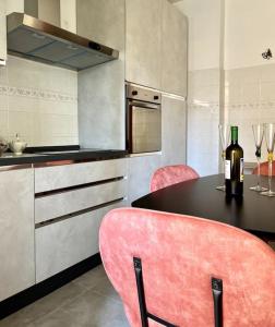uma cozinha com cadeiras cor-de-rosa e uma mesa com uma garrafa de vinho em La Ca Dei Nonni em Monterosso al Mare