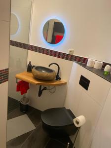 bagno con servizi igienici neri e specchio di Ferienwohnung sentio-comfortable Saalfeld a Saalfeld
