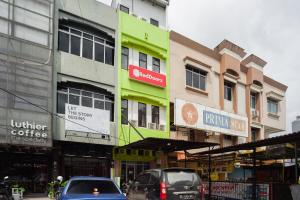 a city street with cars parked in front of buildings at RedDoorz at Jalan Bangau Palembang in Palembang