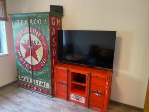 a tv on top of a red dresser with a tv at Ferienwohnung sentio-comfortable Saalfeld in Saalfeld