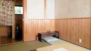een kamer met een houten muur met een tafel en een raam bij Washi Studio Kamikoya in Yusuhara +32 foto's