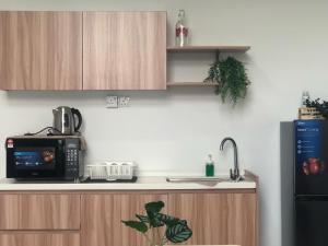 a kitchen counter with a microwave and a refrigerator at Minimalist Boho Loft,2-6pax, The Curve, IKEA, Bandar Utama, Damansara in Petaling Jaya