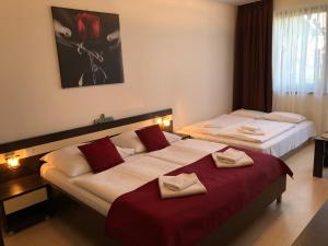 Dos camas en una habitación de hotel con toallas. en Bešeňová Apartmán Relax, en Bešeňová