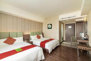 花蓮市的住宿－麗軒國際飯店，酒店客房配有两张床和一张书桌