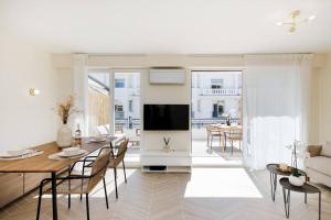 a living room with a dining table and a television at Martinez area Superb 1 bed w XXL terrace in Cannes