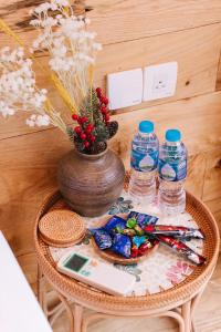 a table with a vase and water bottles on it at Na Thẩm Eco Hill Homestay - Trạm Tấu in Cham Ta Lao