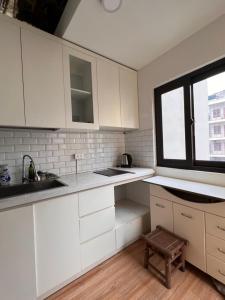a white kitchen with a sink and a window at French-styled house in Hanoi