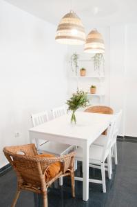 uma sala de jantar branca com uma mesa e cadeiras brancas em Felipe Antón Suites em Mutxamel