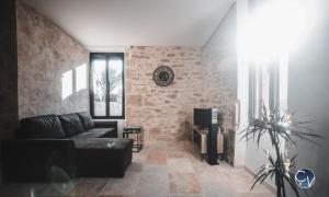 uma sala de estar com um sofá e uma parede de tijolos em Mazet en pierre avec jardin privatif em Sernhac