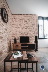 a living room with a wooden table and a tv at Mazet en pierre avec jardin privatif in Sernhac