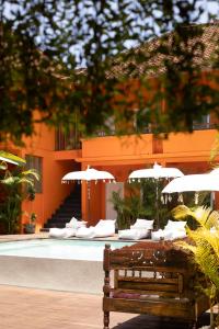 a bench sitting in front of a pool with umbrellas at The Room Padang-Padang in Uluwatu