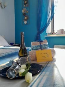 a bottle of wine and glasses on a bed at La Casa di Carta FIUGGI in Fiuggi
