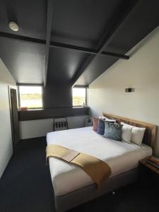 a bedroom with a large white bed with pillows at Thousand Lakes Lodge in Liawenee