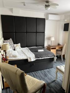 ein Schlafzimmer mit einem großen Bett und einem Stuhl in der Unterkunft Hotel Dijkzicht in Oudeschip