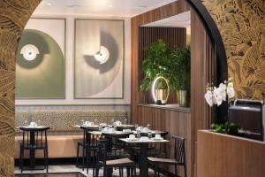 a restaurant with tables and chairs in a room at Hotel Khla Nice in Nice