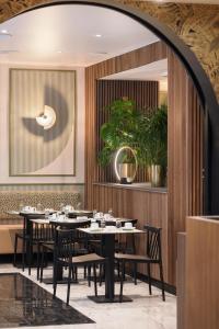 a dining room with tables and chairs and a mirror at Hotel Khla Nice in Nice