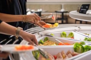 a person preparing food in a buffet at Hotel Khla Nice in Nice