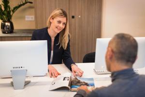 a woman sitting at a table with a man in a meeting at Hotel Khla Nice in Nice