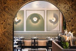 an arched doorway into a restaurant with tables at Hotel Khla Nice in Nice