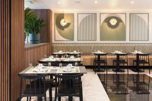 a restaurant with tables and chairs in a room at Hotel Khla Nice in Nice