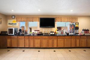 une cuisine avec un grand bar et une télévision à écran plat dans l'établissement Days Inn by Wyndham Dallas Irving, à Irving