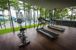 um ginásio com três bicicletas de exercício numa sala com janelas em Maxhome Premium at Dorsett Bukit Bintang em Kuala Lumpur