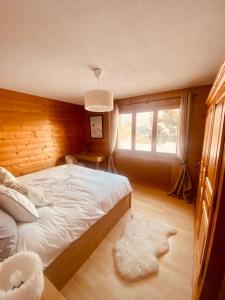 um quarto com uma cama branca e uma janela em 3,5 pces - 80m2- Villars-sur-Ollon em Ollon