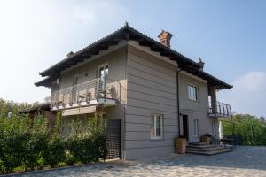 ein Haus mit einem Balkon an der Seite in der Unterkunft Il Riccio e la Castagna - Country House in Montaldo Roero
