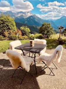 Ollon的住宿－3,5 pces - 80m2- Villars-sur-Ollon，一张桌子和四把椅子,桌子和椅子,山脉