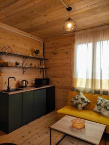 a living room with a yellow couch and a kitchen at Limoncello in Batumi