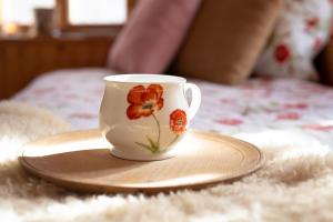 a coffee cup sitting on a plate on a bed at Bezgova Hišica in Bovec