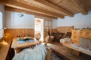 ein Wohnzimmer mit einem Tisch und einer Holzdecke in der Unterkunft Bezgova Hišica in Bovec