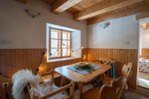 a dining room with a wooden table and chairs at Bezgova Hišica in Bovec