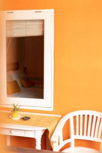 a mirror on a wall with a table and a chair at The Room Padang-Padang in Uluwatu
