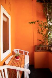 an orange room with a table and chairs and a window at The Room Padang-Padang in Uluwatu