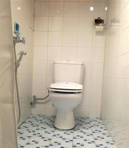 a bathroom with a white toilet in a stall at Ue Datu Cottages in Tentena