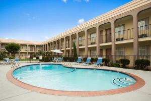 une grande piscine devant un immeuble dans l'établissement Days Inn by Wyndham Dallas Irving, à Irving