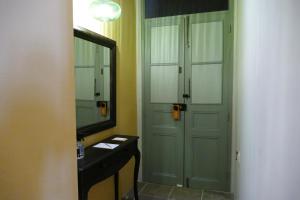 ein Badezimmer mit einer grünen Tür und einem Spiegel in der Unterkunft Madama Residence in Nikosia