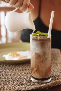 a person drinking a iced drink with a straw at The Room Padang-Padang in Uluwatu