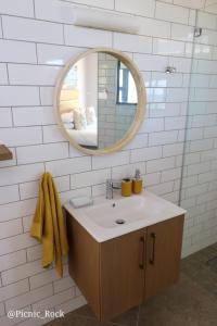 a bathroom with a sink and a mirror at Picnic Rock Seaside Accommodation in Keurboomstrand +48 photos