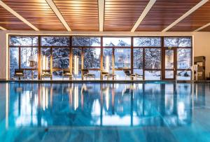 una piscina in una casa con una grande finestra di Romantik Hotel Schweizerhof & Spa a Flims