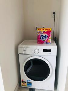 een witte wasmachine met een doos erop bij Cozy Brand New Townhouse 26 in Auckland