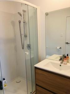 een badkamer met een glazen douche en een wastafel bij Cozy Brand New Townhouse 26 in Auckland
